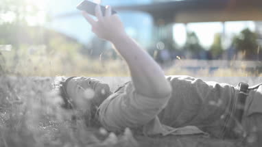 Trendy male sunbathing in long grass