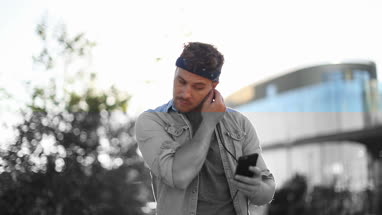 Trendy male listening to music in city