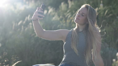 Young adult female taking selfie in nature