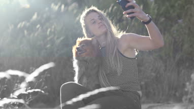Young adult female taking selfie with dog