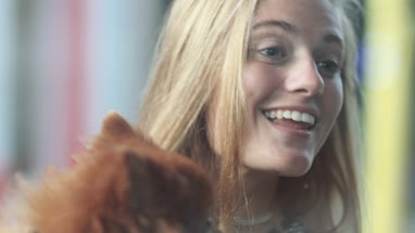 Young female with pet dog window shopping