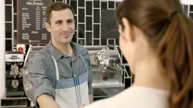 Barista serving business woman in cafe