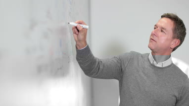 Professor writing on whiteboard