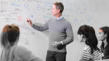Professor teaching with whiteboard notes