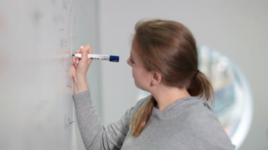 Student writing on whiteboard