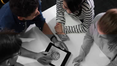 Students with digital tablet looking at design drawing