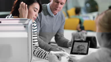 Students discussing 3D printer with teacher