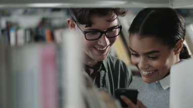 Students using smartphone in library