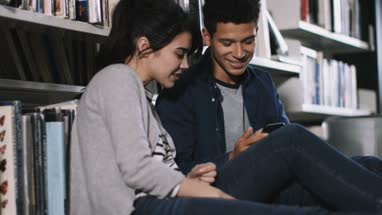 Students using smartphone in library