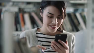Student using smartphone in library