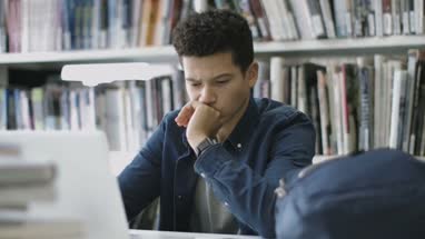 Student studying in library with laptop