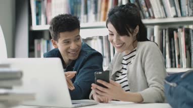 Students using smartphone in library