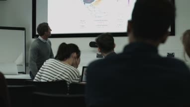 Professor teaching with projector synced to students digital tablets