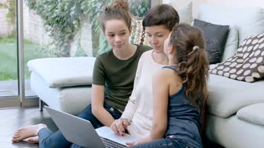 Mom with daughters using laptop together