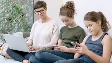 Mom with daughters all using technology