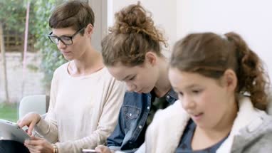 Mom with daughters all using technology