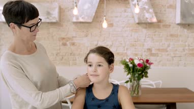 Mom plaiting daughters hair