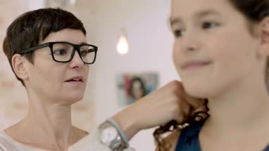 Mom plaiting daughters hair