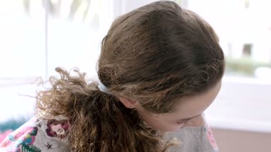Teenager learning to play guitar in her room