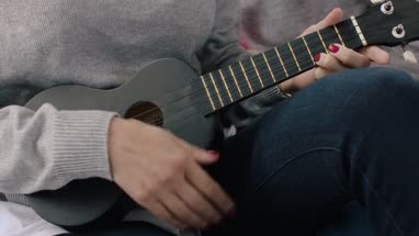 Mom playing ukulele to kids