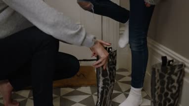 Mom helping daughter put on welly boots