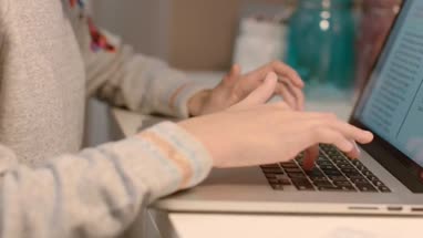 Teenager working on homework on laptop