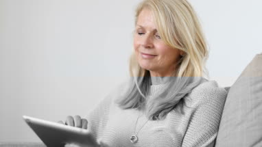 Mature woman at home using digital tablet