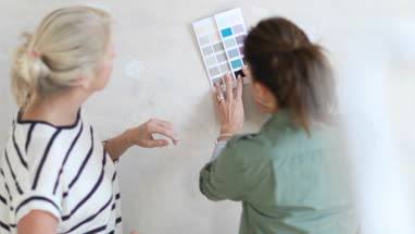 Mature female friends looking at colour card