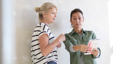 Mature female friends looking at colour card
