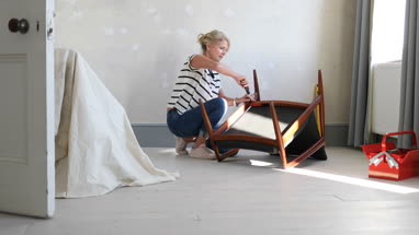Mature female repairing an old chair