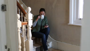 Mature female sitting on staircase in home renovation