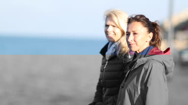 Mature female friends looking out to sea