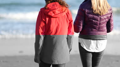 Mature female friends walking on beach