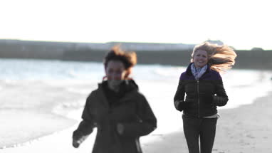 Mature female friends running outdoors