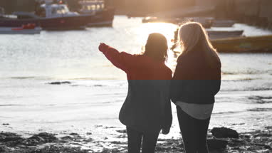 Mature female friends talking in harbour