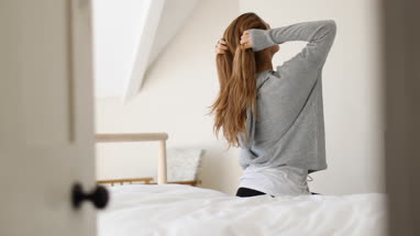 Young adult female getting up in the morning