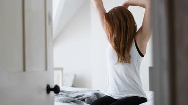 Young adult female getting up in the morning