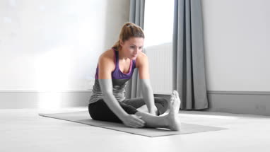 Young adult female doing yoga at home
