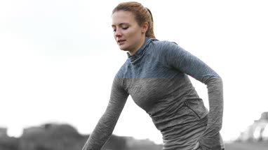 Young adult female stretching on bench