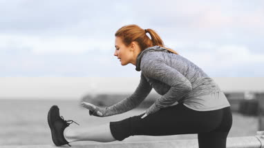 Young adult female stretching outdoors