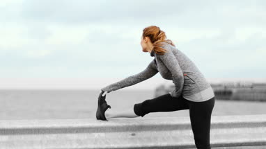 Young adult female stretching outdoors