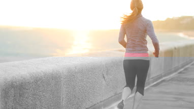 Young adult female running and stretching outdoors
