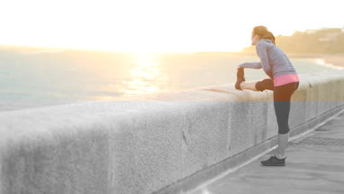Young adult female running and stretching outdoors