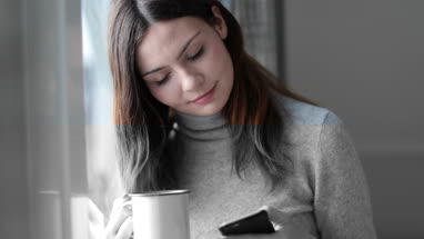 Woman checking smartphone in morning