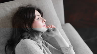 Woman relaxing at home on sofa