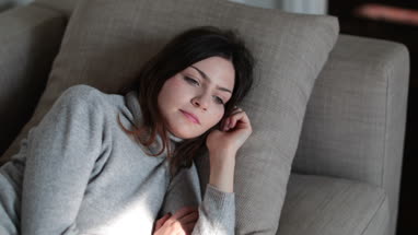 Woman relaxing at home on sofa