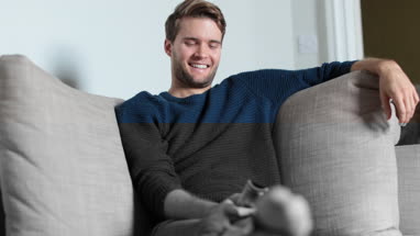 Man watching TV at home on sofa