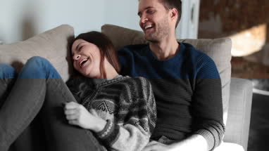 Couple relaxing on sofa at home