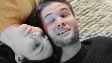 Couple lying down on rug in new home