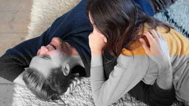 Couple lying down on rug in new home
